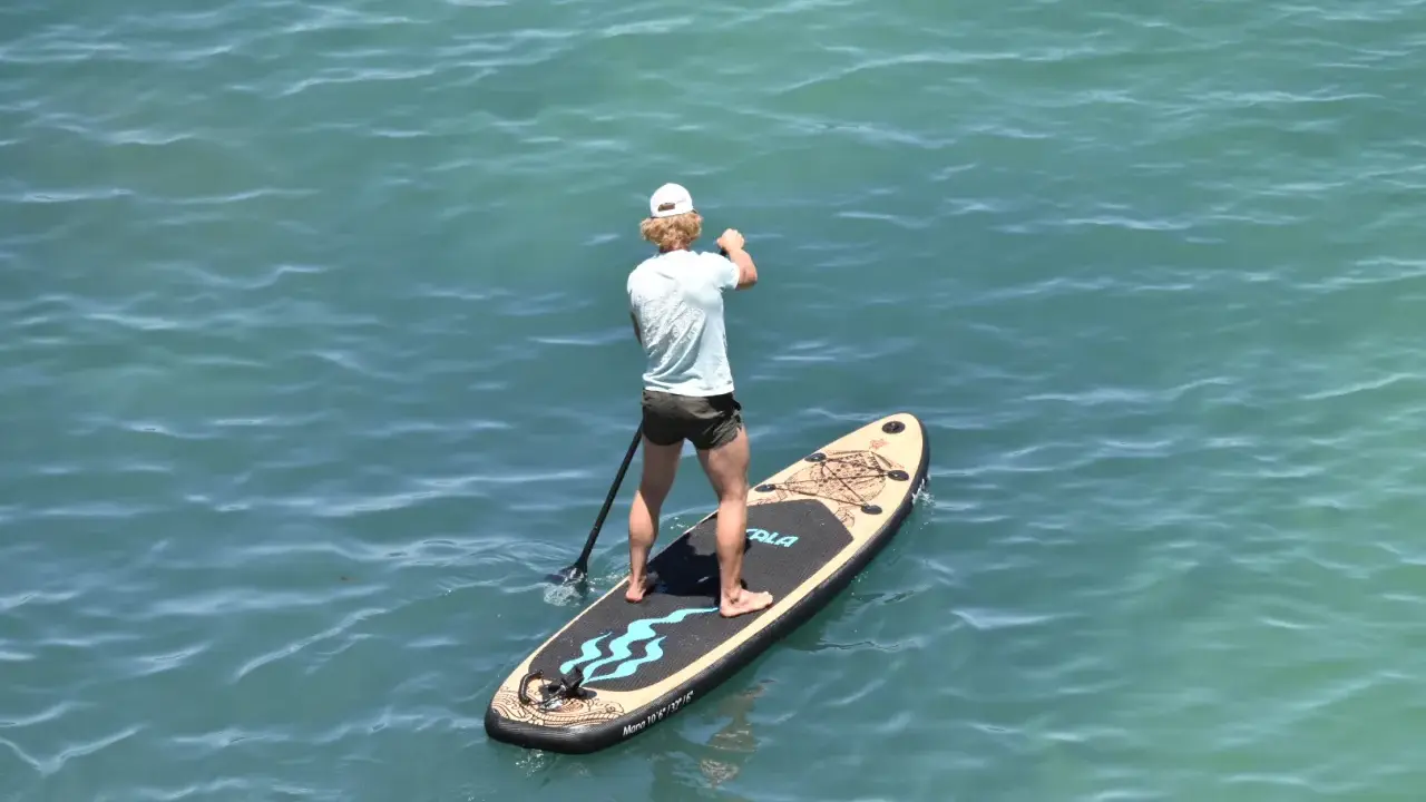 Mann auf SUP-Board vor Mallorca, genießt das ruhige Meer.