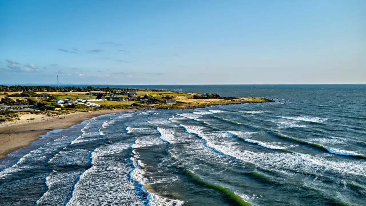 Wellen brechen an der Küste Schwedens. Ein einsamer Windsurfer genießt die Bedingungen.