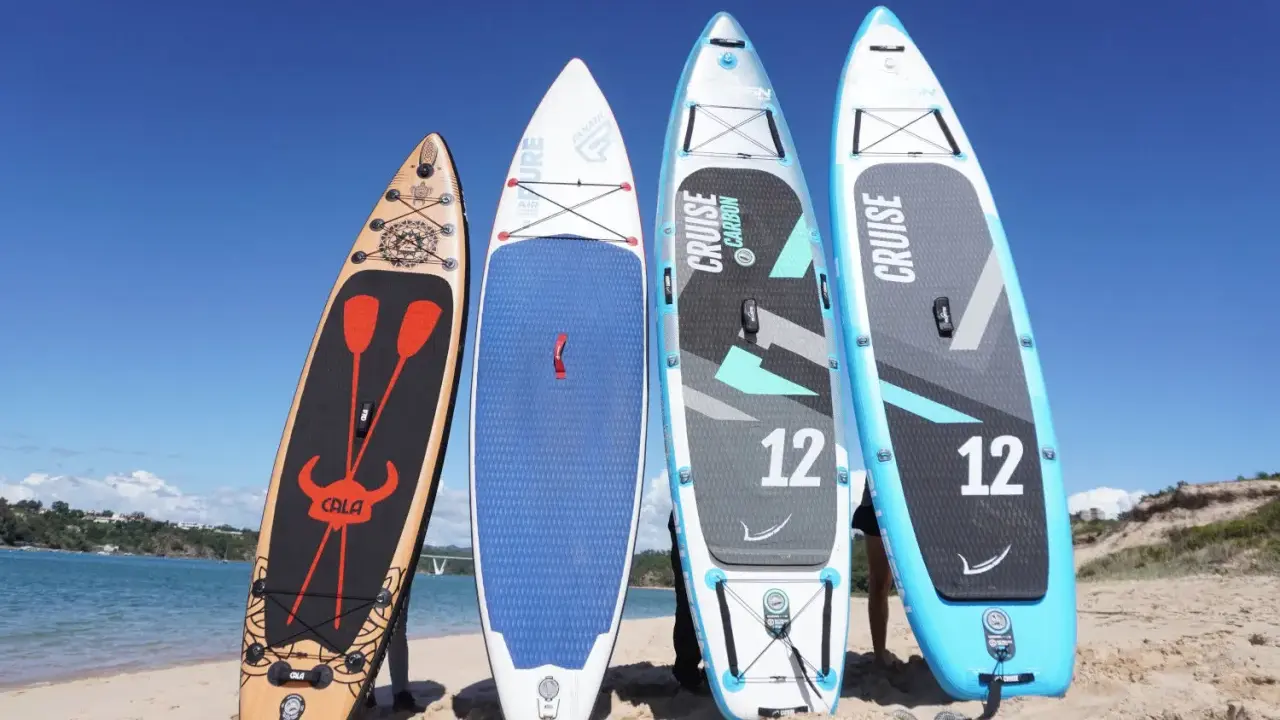 Vier aufrecht stehende Standup Boards am Strand, bereit für das Wasser.
