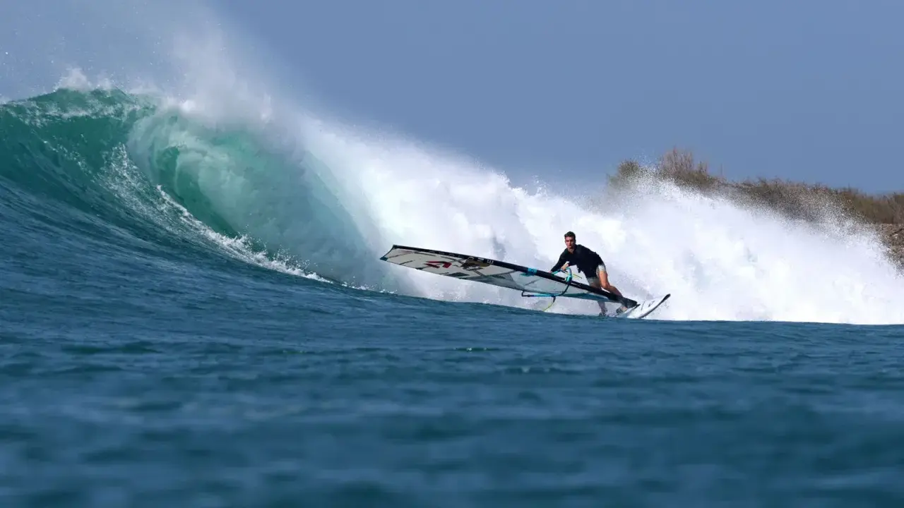 Liam Dunkerbeck surft eine massive Welle, die Gischt spritzt.