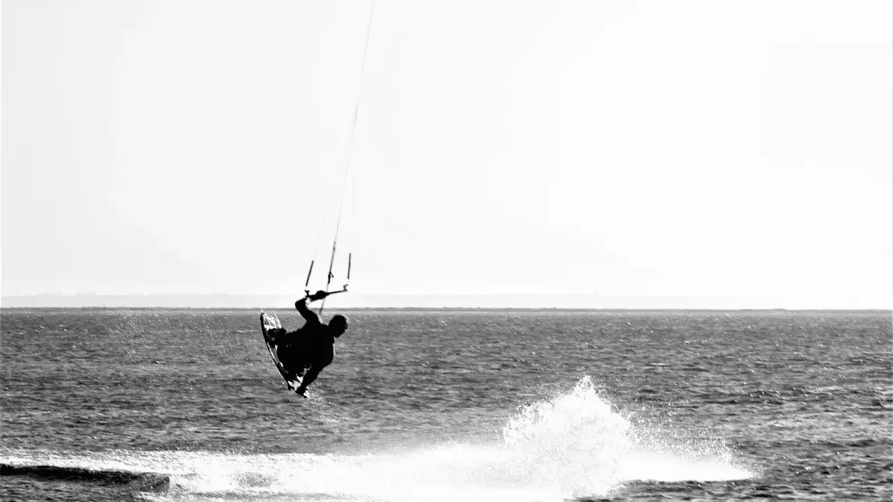 Kitesurfer in der Luft vor Fehmarn. Ein Sprung über das Wasser, der die Freiheit des Windsurfens zeigt.