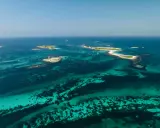 Türkisblaues Wasser umgibt die Glenan Inseln mit einem Leuchtturm auf einer kleinen Insel.