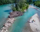 Standup paddling am Feldmarksee: Zwei Personen ruhen sich auf einer Kiesbank aus, während zwei Boards im türkisfarbenen Wasser liegen.
