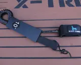 Schwarze SUP Leash mit 10' Kennzeichnung und Mint Lama Logo, bereit zur Befestigung.