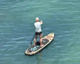 Mann auf SUP-Board vor Mallorca, genießt das ruhige Meer.