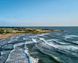 Wellen brechen an der Küste Schwedens. Ein einsamer Windsurfer genießt die Bedingungen.