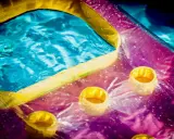 Bunte Luftmatratze mit Becherhaltern im Wasser, bereit zum Luftmatratze flicken.