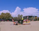 Kitesurfer bereiten sich am Strand von Roses auf den Sport vor.