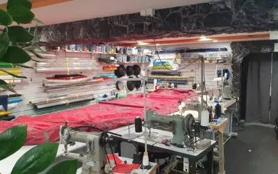 Werkstatt für wing reparatur mit Nähmaschinen und Stoffrollen.