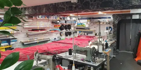 Werkstatt für wing reparatur mit Nähmaschinen und Stoffrollen.