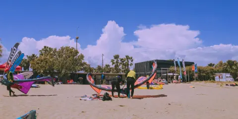 Kitesurfer bereiten sich am Strand von Roses auf den Sport vor.