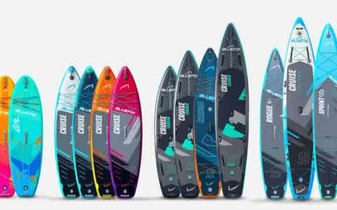 Vielfalt an SUP-Boards in verschiedenen Farben und Größen, die eine SUP Board Größen Tabelle illustrieren.