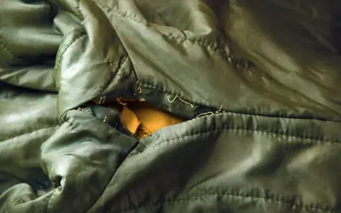 Ein Loch in einer grünen Regenjacke, bereit zum reparieren.
