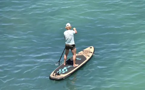 Mann auf SUP-Board vor Mallorca, genießt das ruhige Meer.