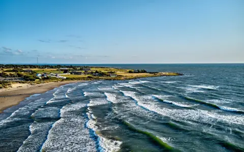 Wellen brechen an der Küste Schwedens. Ein einsamer Windsurfer genießt die Bedingungen.