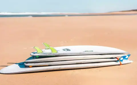 Gestapelte Surfbretter am Strand, verschiedene surfbrett größe für unterschiedliche Wellen.