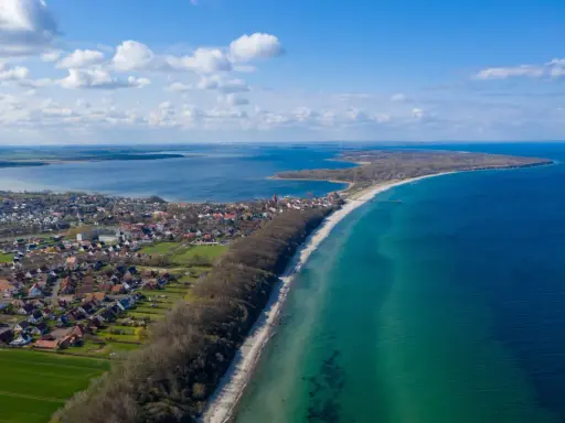 Luftaufnahme von Pepelow am See, mit Häusern, Strand und dem blauen Meer. Perfekt zum **pepelow surfen**.