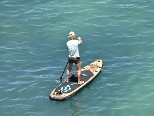Mann auf SUP-Board vor Mallorca, genießt das ruhige Meer.