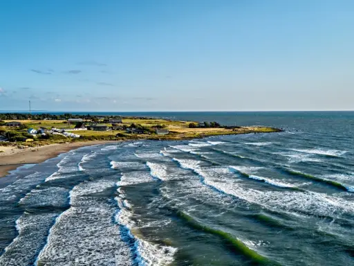 Wellen brechen an der Küste Schwedens. Ein einsamer Windsurfer genießt die Bedingungen.