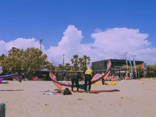 Kitesurfer bereiten sich am Strand von Roses auf den Sport vor.