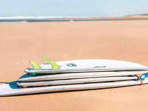 Gestapelte Surfbretter am Strand, verschiedene surfbrett größe für unterschiedliche Wellen.