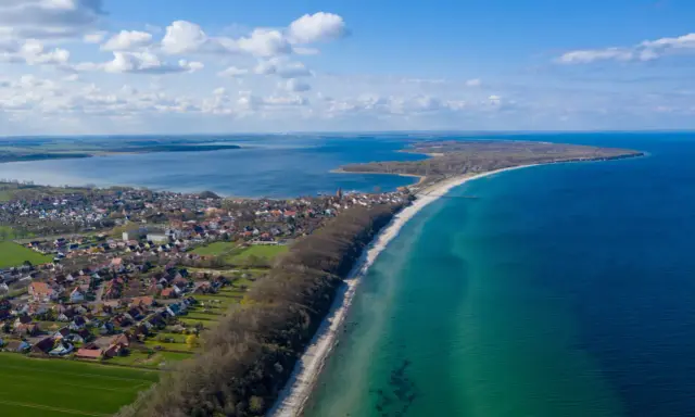 Luftaufnahme von Pepelow am See, mit Häusern, Strand und dem blauen Meer. Perfekt zum **pepelow surfen**.