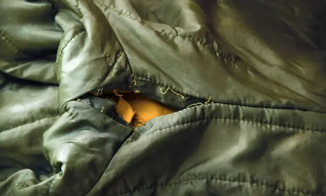 Ein Loch in einer grünen Regenjacke, bereit zum reparieren.