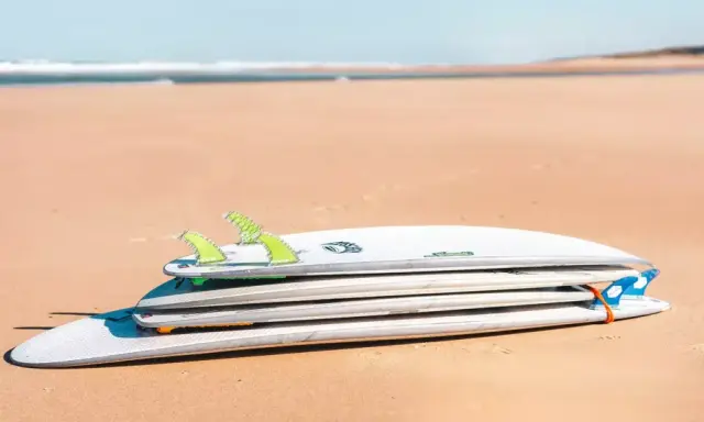 Gestapelte Surfbretter am Strand, verschiedene surfbrett größe für unterschiedliche Wellen.
