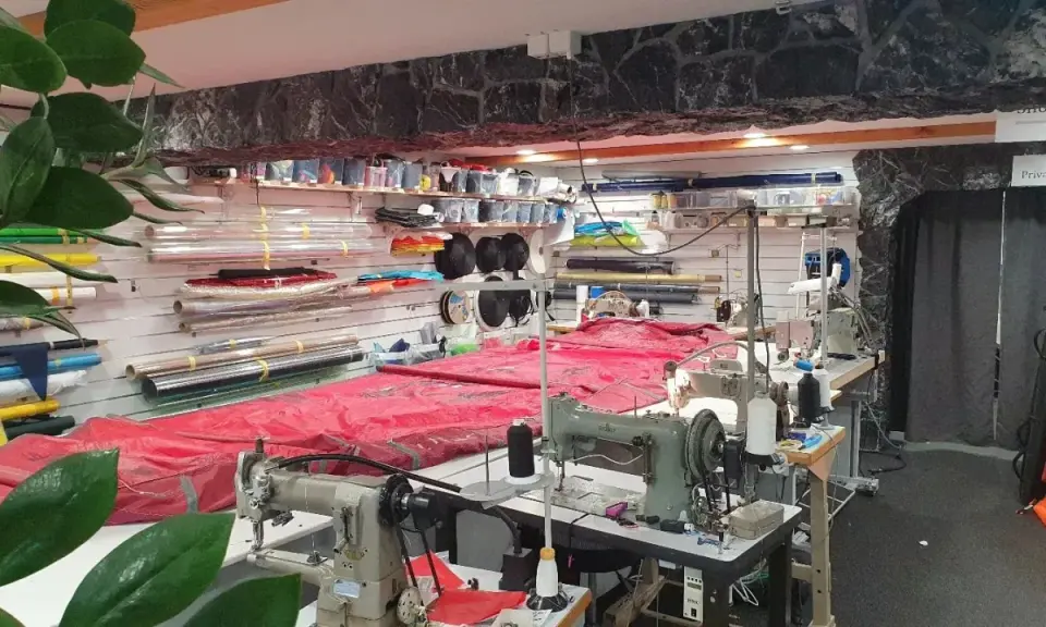 Werkstatt für wing reparatur mit Nähmaschinen und Stoffrollen.
