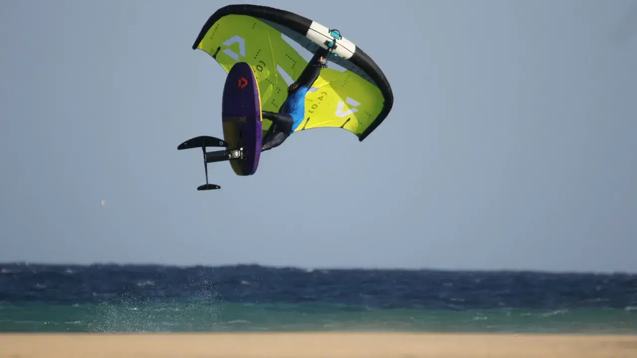 Wingfoiler springt hoch &uuml;ber dem Meer bei Costa Calma. Ein Action-Shot vom Ion Club.
