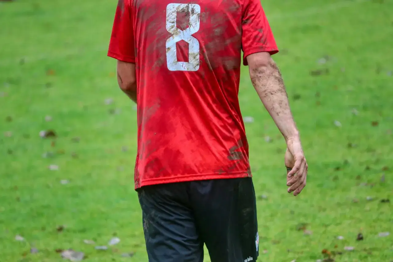 Fu&szlig;ballspieler mit schmutzigem roten Trikot und der Nummer 8. Nach dem Spiel m&uuml;ssen die trikots waschen.