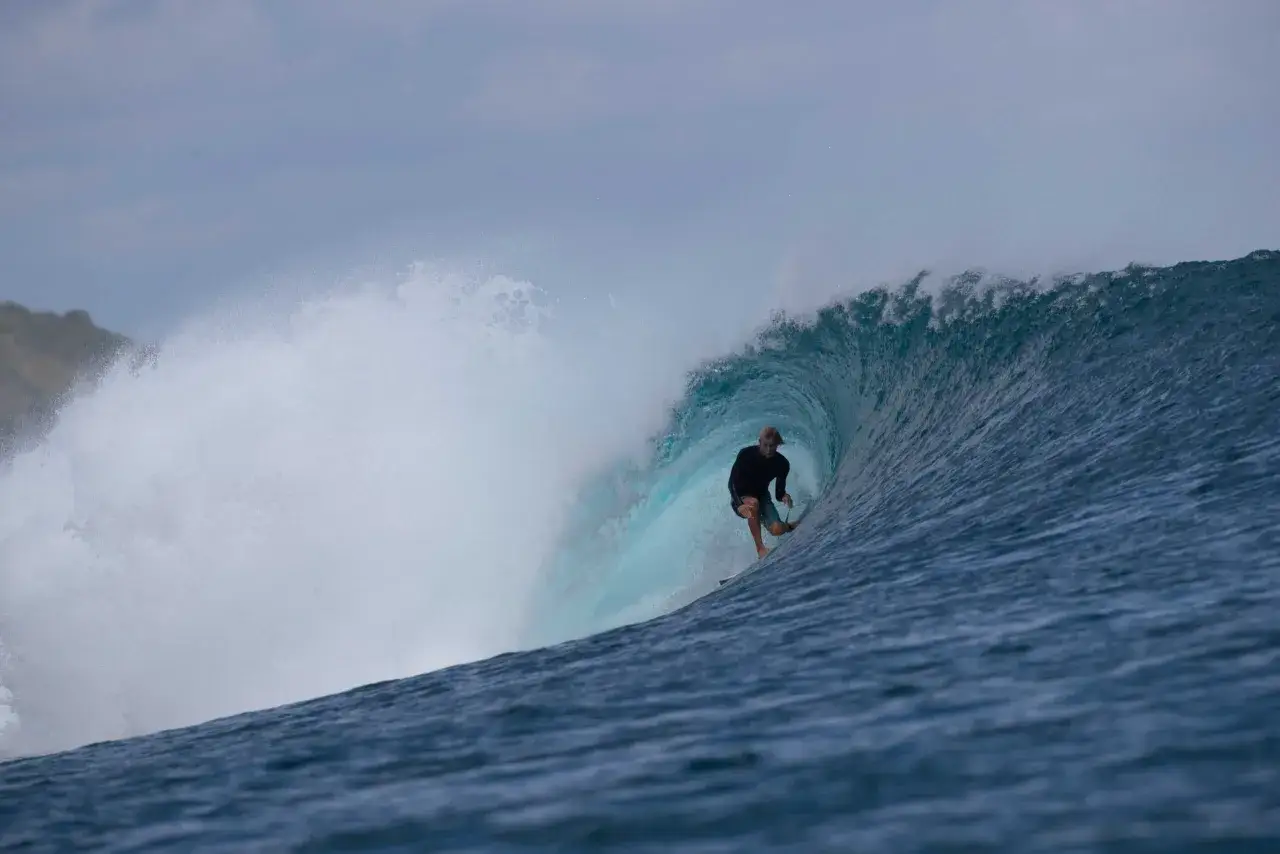 Surfer reitet eine Welle in einem perfekten Barrel. Die Surf-App zeigt diese Action-Aufnahme.