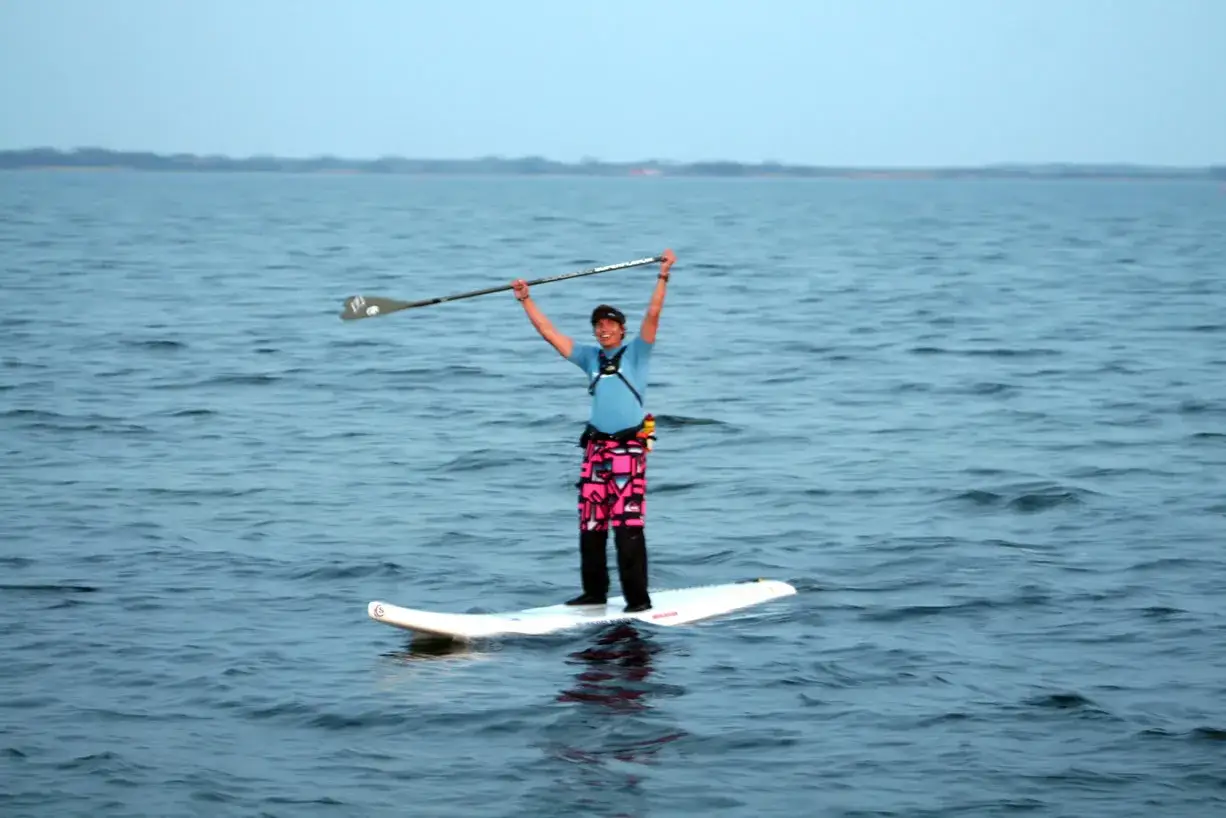 Mann jubelt auf seinem SUP-Board vor Fehmarn.
