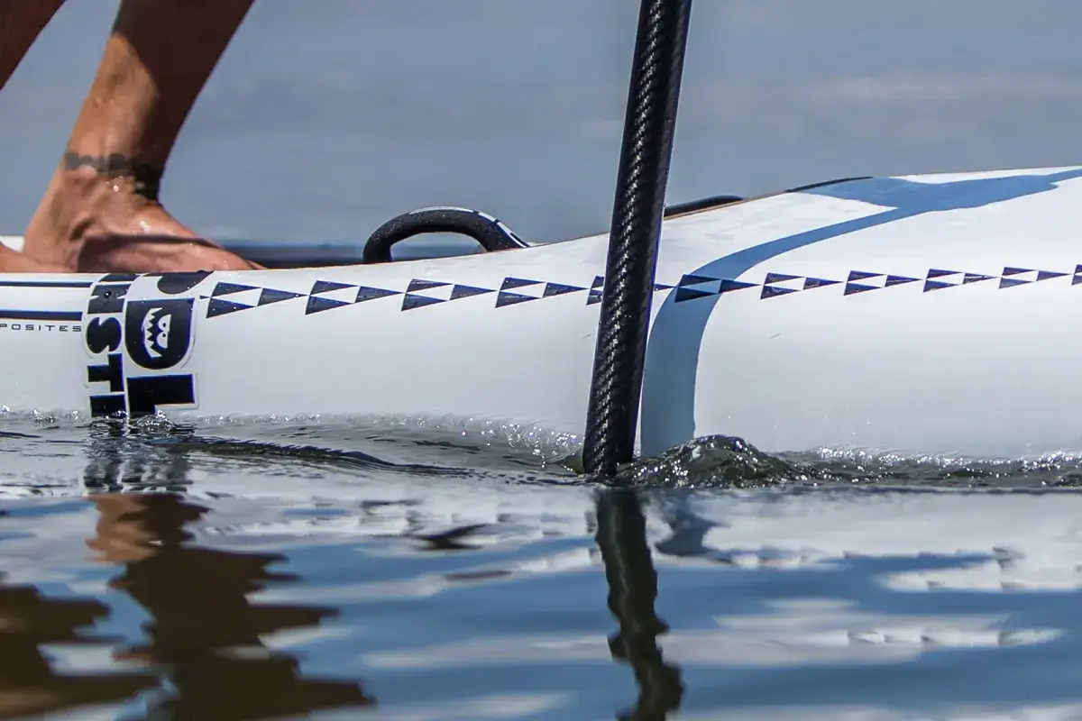 SUP-Paddel richtig halten: Ein Fuß auf dem Board, das Paddel im Wasser.