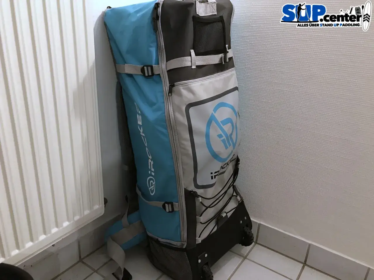 Gro&szlig;er Rucksack mit Rollen, ideal zum SUP lagern. Er ist blau und grau, mit dem iRocker Logo.