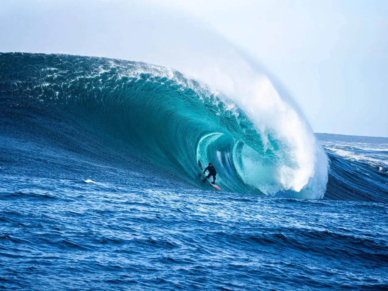 Surfer reitet eine riesige Welle, die sich in Schweden zu einem Tunnel formt.