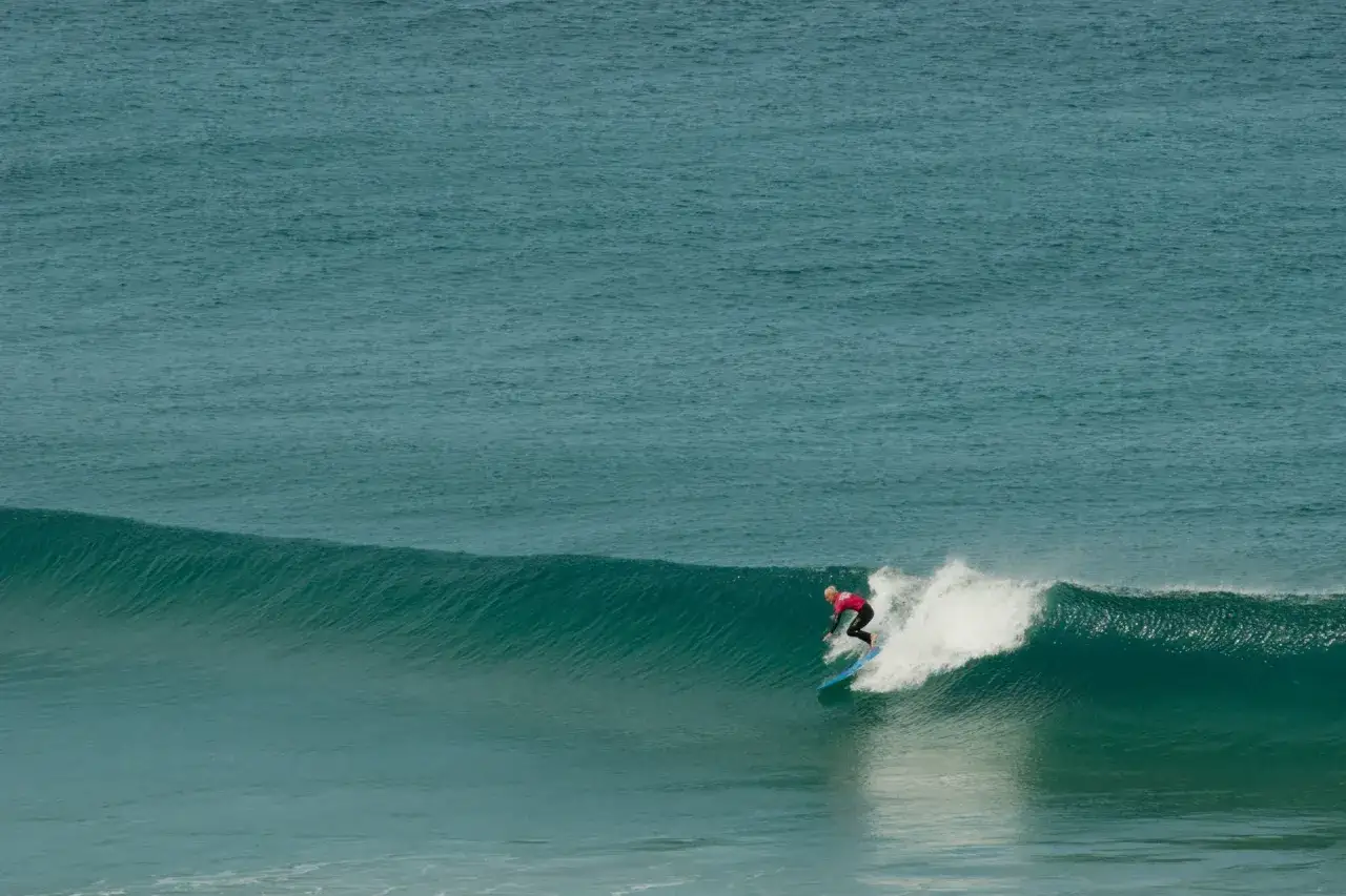 Surferin reitet eine Welle vor der K&uuml;ste von Fuerteventura. Das costa calma surfen ist hier ein Erlebnis.
