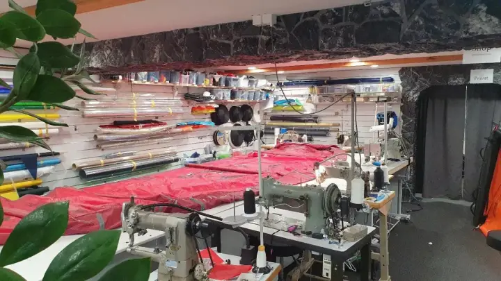 Werkstatt für wing reparatur mit Nähmaschinen und Stoffrollen.